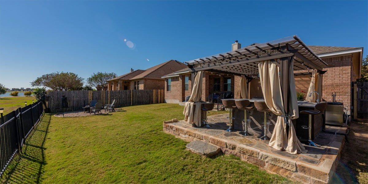 backyard with patio and pergola covering outdoor kitchen with bar