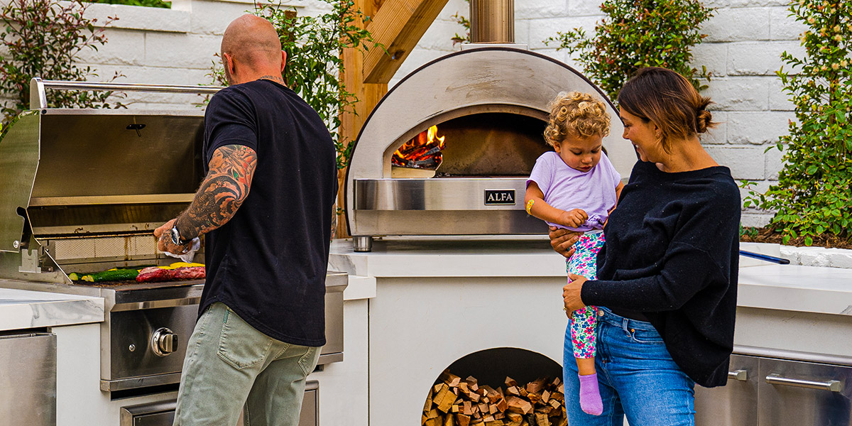 family enjoying cooking at an outdoor kitchen