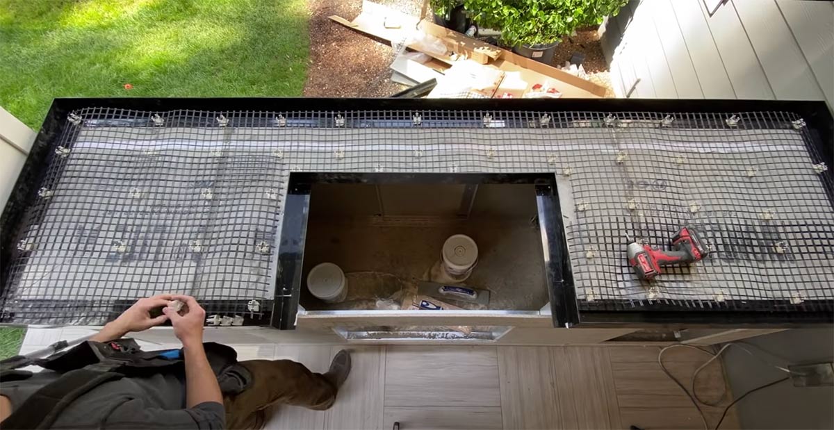 man laying mesh reinforcement on concrete countertop form