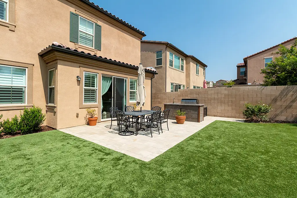 outdoor kitchen island on patio with built in grill and drop in cooler