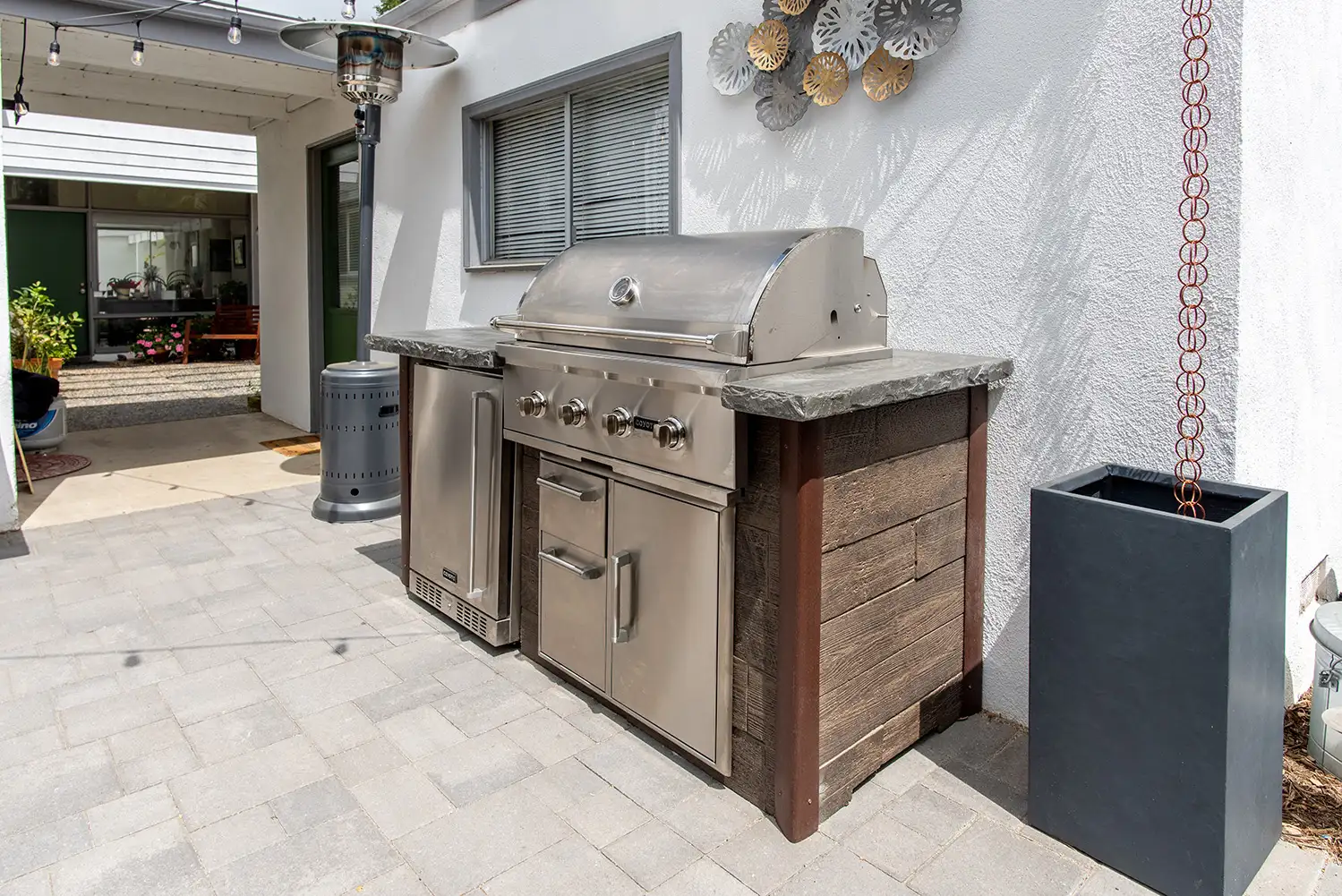 small outdoor kitchen setup on patio with built in grill and sink